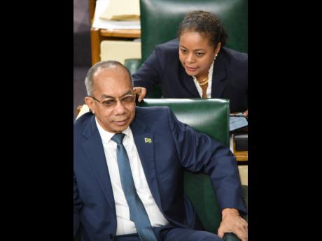 Minister of Legal and Constitutional Affairs Marlene Malahoo Forte leans in to make a sotto voce remark to National Security Minister Dr Horace Chang minutes before he gave an update in Parliament Tuesday on the state of emergency in St Catherine.