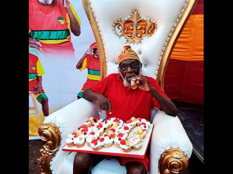Centenarian Theodore Brown takes a sip of Hennessy cognac during a birthday celebration at his Portmore, St Catherine, home last weekend. 