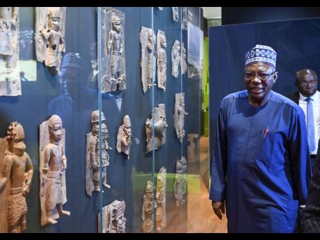 Abba Tijani, director general of the National Museums and Monuments Authority of Nigeria, looks at Benin Bronzes at the Linden Museum. The ethnological museum houses 78 objects, including 64 bronzes, from the former royal house of Benin, whose core area is