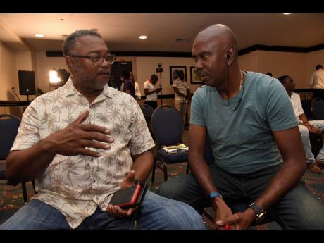 
Harold Thomas (left), coach of Dunbeholden football team, and Ludlow Bernard, coach of Harbour View, share a moment during a press conference to announce details of the Jamaica Premier League final between the teams at the Jamaica Pegasus Hotel in Kingsto