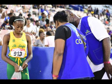 
JADCO doping control personnel make contact with  St Jago’s Machaeda Linton on day two of the JAAA National Senior and Junior Championships inside the National Stadium earlier this month.