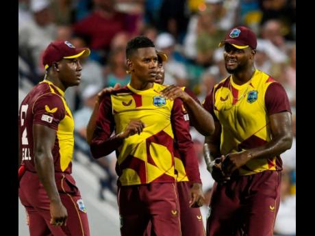 
Akeal Hosein (centre) is congratulated by West Indies teammates from left: Rovman Powell, Odean Smith, and Romario Shepherd.
