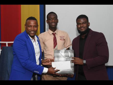 Youth mentor and transformational speaker Conroy Thompson (left) presents a scholarship to St James High School student Dane Dyer (centre), during the official launch of his new book at The University of the West Indies [UWI] West Jamaica campus in Montego