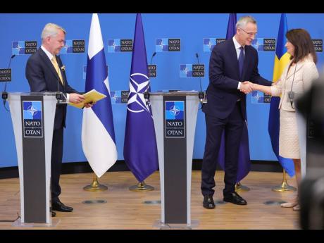 Finland’s Foreign Minister Pekka Haavisto (left), Sweden’s Foreign Minister Ann Linde (right), and NATO Secretary General Jens Stoltenberg attend a media conference after the signature of the NATO Accession Protocols for Finland and Sweden in the NATO 