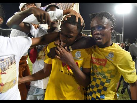 Trayvone Reid (centre) is surrounded by jubilant supporters after Harbour View FC defeated Dunbeholden United 6-5 on penalties in the Jamaica Premier League final at Sabina Park yesterday.