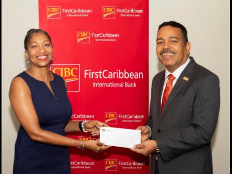 Stephannie Coy, executive director, the United Way of Jamaica (UWJ), accepts a cheque from Nigel Holness, managing director of CIBC FirstCaribbean, in support of the UWJ’s fundraising efforts aimed at addressing critical social issues and transforming li