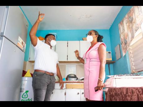 Digicel Foundation Construction Manager Carnel Campbell points out areas for improvement to the Catherine Hall Special Education Unit as he takes his board director, Joy Clark, on a tour of the facility prior to commencing renovations.