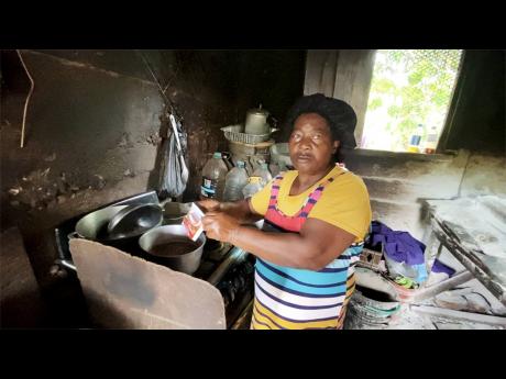 Yvonne Fearon in her kitchen making tea with one sachet of Lasco chocolate milk powder. Her family of four stretches the contents with sugar, water, and milk to ensure that everyone gets a cup. A report published Wednesday shows that two million Jamaicans 