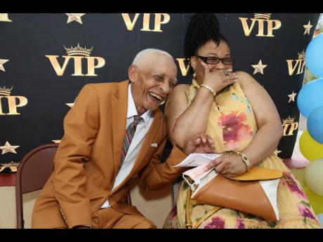 Eustace ‘Jockey Roy’ Richards of Crofts Hill, Clarendon, laughs alongside his eldest daughter Maurine as he recalls his many donkey races over the years. He received a Community Service Award from One Connection on June 25.