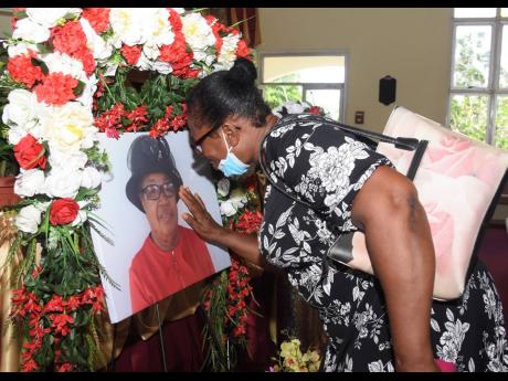 Halcyon Norman touches the portrait of her 68-year-old friend, Beryl Walters, during her thanksgiving service at the Mount Salem Seventh-day Adventist Church in Montego Bay, St James, on Wednesday.