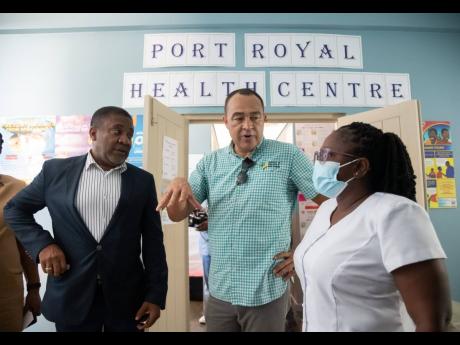 Minister of Health and Wellness Dr Christopher Tufton (centre) and member of parliament for Kingston East and Port Royal, Phillip Paulwell,  engage in a conversation with Tanya Edwards, midwife at the Port Royal Health Centre, following the official ceremo