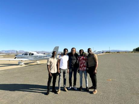 Dushyant Savadia (centre), founder and CEO of the Amber Group, is flanked by Amber Aviation trainee pilots (from left) Arnold Avis, Alando Perry, Nathaniel McCreath, and Orlando Stephenson. 