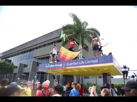 When the trucks and the street could no longer contain their exuberance, these revellers climbed atop a Guardian Group bus stop.
