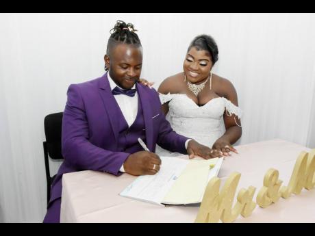 As Mr James seals the deal by signing the marriage certificate, a happy Mrs James looks on with approval.
