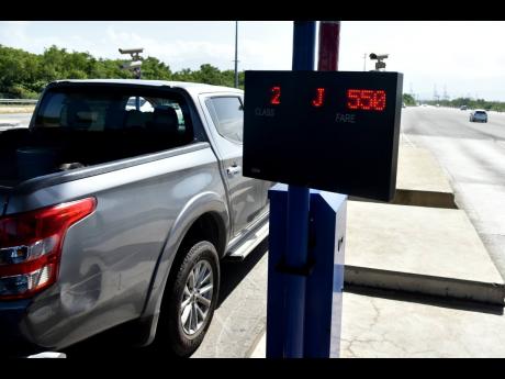 A Class Two motorist proceeds after paying the new toll fee of $550 at the Portmore toll plaza Monday. Class Three operators are charged $1,020.