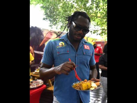 Reggae Sumfest’s Cordel ‘Skatta’ Burrell grabs a plate of the Thai coconut curried chickpeas, jerked sweet corn and roasted breadfruit.