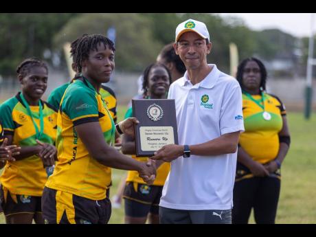 Jamaica’s captain Shanique Smith receives the runner-up plaque from Portfolio Managing Director David Martin of sponsors Jamaica Producers following the final of the Rugby Americas North Women’s Tournament at the UWI Mona Bowl last Saturday.