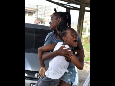Relatives are overcome with emotion after the identities of four men buried in shallow graves at the old Public Works Department complex were confirmed on Tuesday. The men were all from Denham Town.
