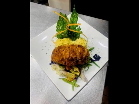 Presentation is just as important as taste for the good chef who plates this deep-fried stuffed chicken breast, served with creamy mashed potatoes and vegetables.