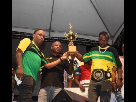 Reggae Sumfest's Dwight James presents the winning trophy to Bass Odyssey's Stennett Waite (left) and Damion 'Delingy' Dwyer at the Global Sound Clash held at Pier 1 in Montego Bay on Thursday. 