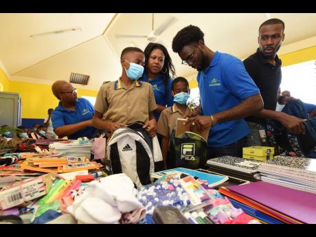 Paulette Mowatt-Donaldson (left), international ambassador of the Living Well Community Care Team; Christine Lewis (centre); Rajieve Miller (second right); and Odane Brown (right) assist Joseph Royal Educational Centre students Ajani Crawford (second left)