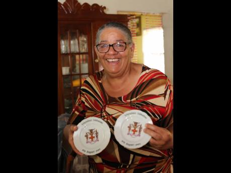 Audrea Shaw-Green, twin sister of politician Audley Shaw, shows off a plate set her parents received at Independence 1962.