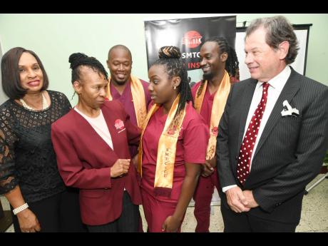 Beverley Dinham-Spencer (second left), principal/director, SMTC Career Institute; Marjorie Sinclair (left), director of nursing at Baywest Wellness Hospital, and Gary Lang (right), COO of the Heart Institute of the Caribbean, chat with graduates, Top Stude