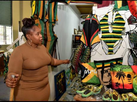 Nicola Ferguson shows off some of her wares at her shop inside the Kingston Craft Market on the waterfront in the capital city on Monday. An anticipated boom in sales amid an increase in cultural events as the Emancipation and Independence holidays draw ne
