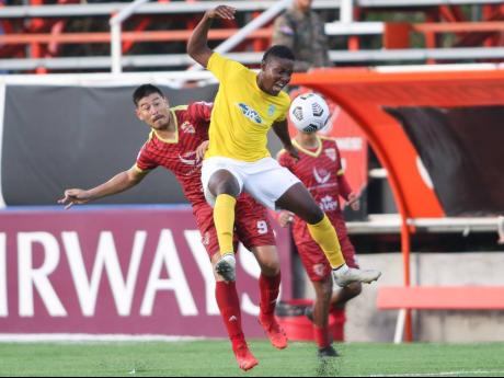 Shequeil Bradford (front) of Waterhouse FC is tackled by Mauro Gomez of Vega Real during the third-place match in the FLOW Concacaf Caribbean Club Championship held at the Estadio Cibao stadium in Santiago de los Caballeros, Dominican Republic, on May 22.