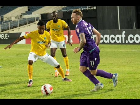 Pacific FC’s Joshua Heard (right) steps away from Waterhouse defenders, Damion Binns (centre) and substitute Zain Hylton during a Scotiabank Concacaf League encounter at Sabina Park on Tuesday.