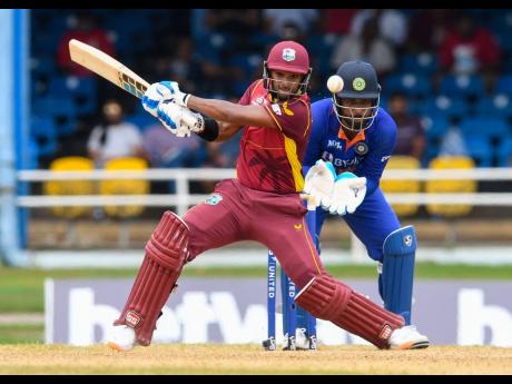 West Indies captain Nicholas Pooran (left) strikes a four as India wicketkeeper Sanju Samson looks on during the second ODI at Queens Park Oval, Port of Spain, Trinidad and Tobago, on Sunday.
