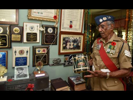 Retired Sergeant Peter Xavier Williams  shows off some of the awards he has received over the years.