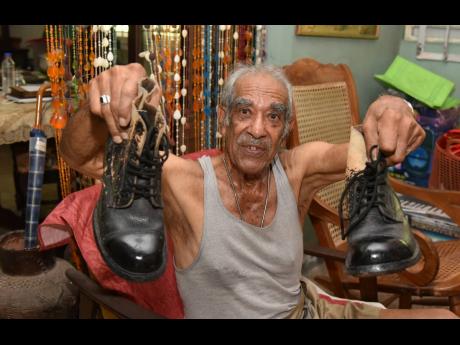 Eighty-nine-year-old retired army Sergeant Peter Xavier Williams shows off the boots he wore throughout his years in service since first joining the Jamaica Battalion in 1952.