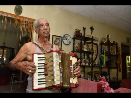 Retired Sergeant Peter Xavier Williams plays a tune on his piano accordion.