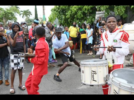 A man dances in the street while the Magnificent Troops marching band play in Mandeville, Manchester, as part of a float parade on Thursday. The festivities are part of Jamaica’s celebration of its 60th anniversary of Independence, which climaxes on Augu
