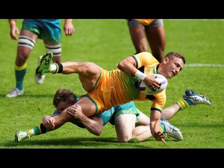 Jamaica’s Gareth Stoppani (right) is tackled by Australia’s Josh Turner during a Men’s Pool D Rugby Sevens match on day one of the 2022 Commonwealth Games at Coventry Stadium in Coventry, England yesterday. Australia won 62-0.