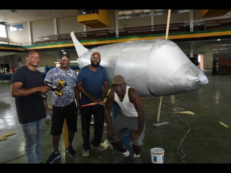 Members of the Emancipation Day float-making technical team, (from left) Allan Henry, Patrick Richards, Gavin Wright, Rohan Gowie, pose beside their handiwork inside the National Arena. 