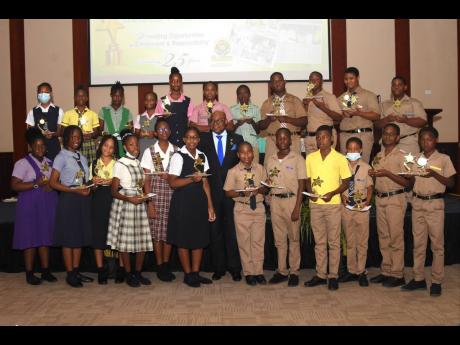 Edmund Bartlett (centre), member of parliament for St James East Central, poses for a group photo with the top performing boys and girls from 14 primary and all-age schools in the East Central St James constituency.  The students were  awarded through his 