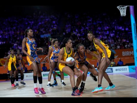 Jamaica’s Adean Thomas (centre) takes control of the ball during a Netball Pool A match against Barbados at the Commonwealth Games at The National Exhibition Centre in Birmingham, England yeterday.