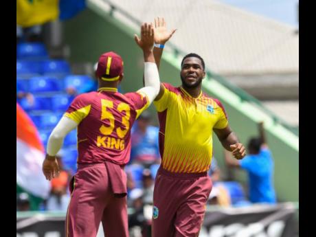 West Indies Obed McCoy (right) celebrates the dismissal of India’s Rohit Sharma during the second T20I between the teams at Warner Park in Basseterre, St Kitts and Nevis, yesterday.