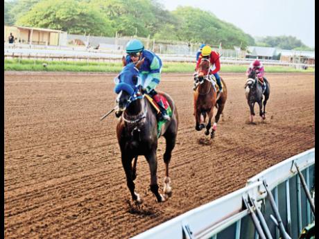 MAHOGANY, ridden by Dick Cardenas, wins the Betting and Gaming Lotteries Commission Trophy, a three-year-old and upwards stakes over five and a half furlongs at Caymanas Park yesterday.