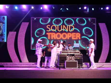 Veteran entertainers hold a reasoning on stage as Sound Trooper cues the next riddim for their performance. 