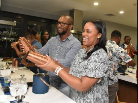 Having fun, while attempting not to spill thier mixes were Business Development Manager of Integrated Chemical Services, Brandon Robinson (left) and Social and Digital Marketing manager of Sagicor Group Jamaica, Charrissa Clemetson.