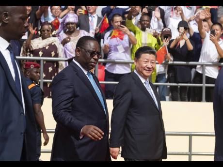 
In this 2018 photo Chinese President Xi Jinping, right walks with Senegal’s president Macky Sall during his state visit, in Dakar, Senegal.