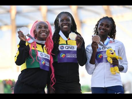 From left: Silver medalist Shelly-Ann Fraser-Pryce; World Champion and gold medalist Shericka Jackson and bronze medalist Dina Asher-Smith, pose with the medal won in the women’s 200m at the World Athletics Championships.