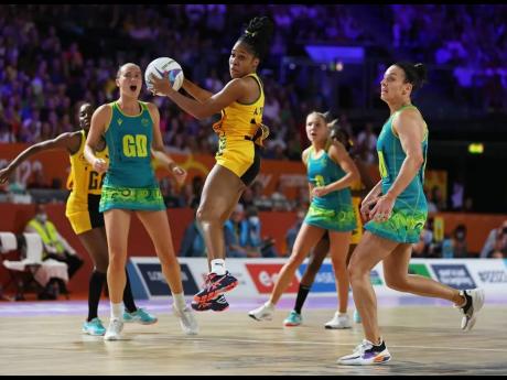 Jamaica’s Adean Thomas (centre) wins the ball in front of Australia’s Ashleigh Brazill (right) during the netball competition’s gold medal match between the teams on day 10 of the Birmingham 2022 Commonwealth Games at NEC Arena yesterday in Birmingha