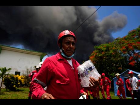 Members of the Cuban Red Cross prepare to be transported to the Matanzas Supertanker Base, where firefighters work to quell a blaze in Matazanas, Cuba.