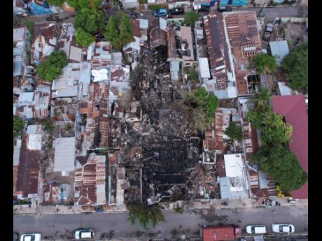 The blackened wreckage amid a maze of tenement yards where a massive blaze left 30 people homeless after criminals launched a firebombing and gun attack on central Kingston residents between Smith Lane and James Street on Monday. 
