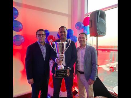American Airlines country manager for Jamaica, Damion Vanriel (centre) holds up the cup proudly. He is flanked from left:  José María Giraldo, Managing Director of Mexico, Central America and the Caribbean and José A. Freig, vice president of Internatio