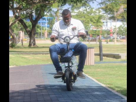 A man rides his bicycle in the Harmony Beach Park in Montego Bay, St James.